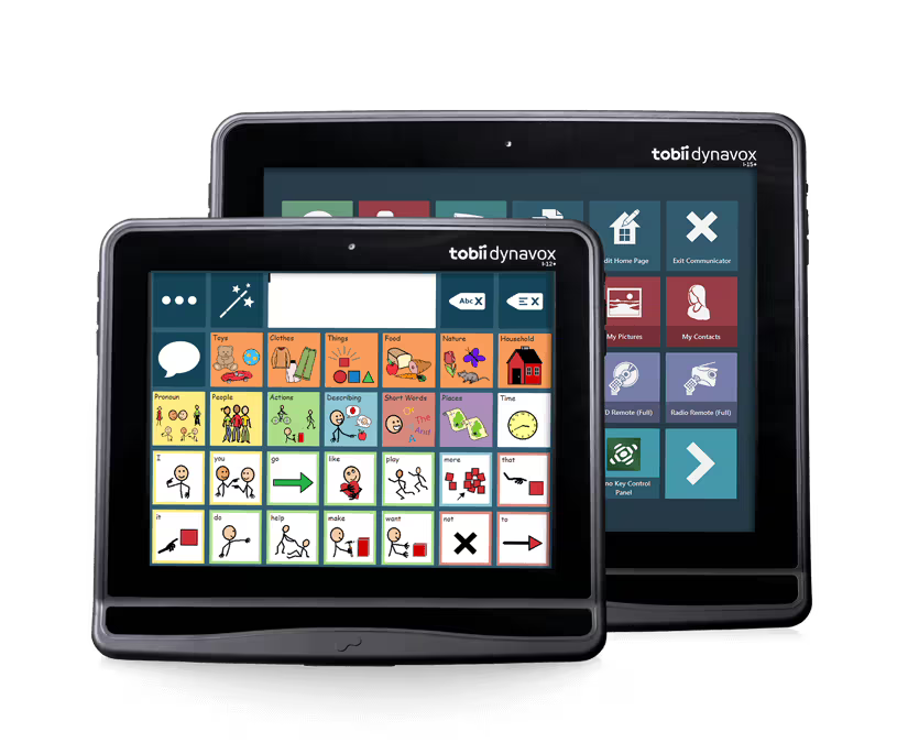 Two Tobii Dynavox tablet devices shown on a plain white background, one in front of the other. The front tablet displays a colorful icon-based user interface, and the rear tablet shows a darker app screen with various control tiles.