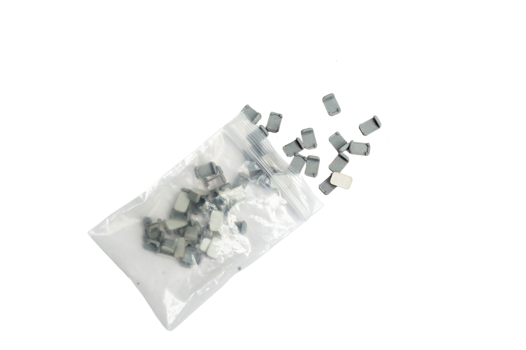 Small rectangular components spilled from a clear plastic bag on a plain white background.
