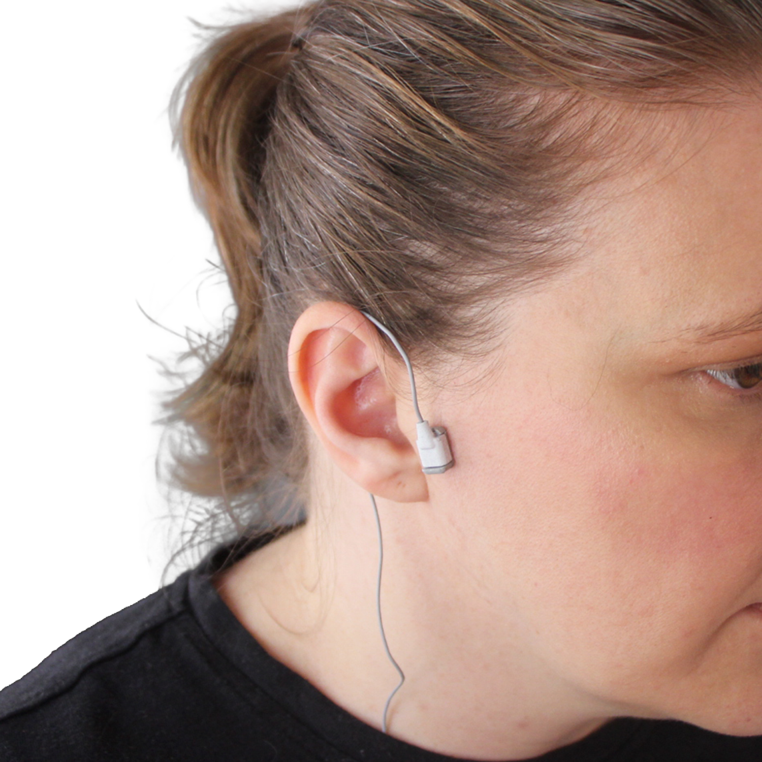 A close-up side profile of a person wearing a small white sensor with a thin wire, shown against a plain white background.