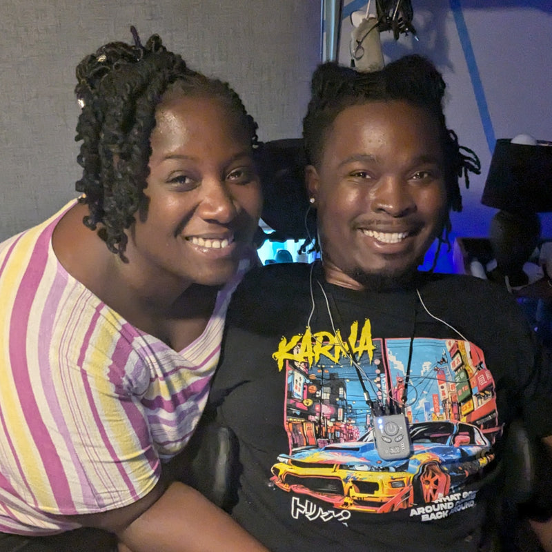Two people posing together with a colorful shirt featuring a graphic design.